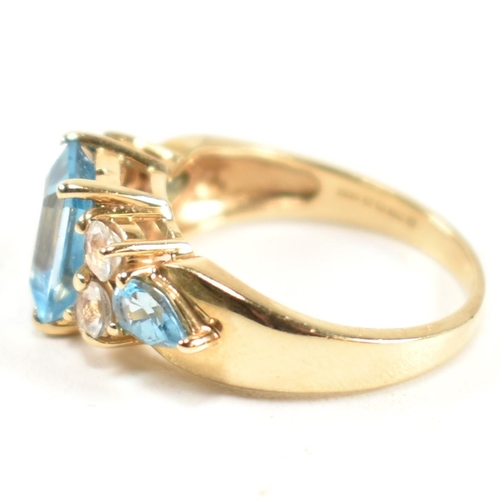 239 - A hallmarked 9ct gold, blue topaz and white topaz ring. The ring set with a central emerald cut blue... 