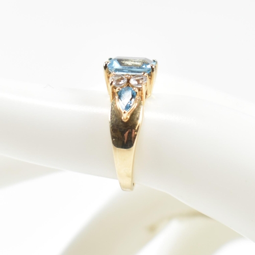 239 - A hallmarked 9ct gold, blue topaz and white topaz ring. The ring set with a central emerald cut blue... 