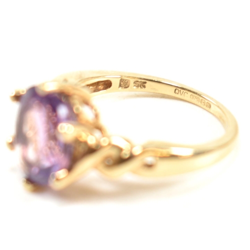 248 - A hallmarked 9ct gold and amethyst ring. The ring having a central six claw set oval cut amethyst to... 