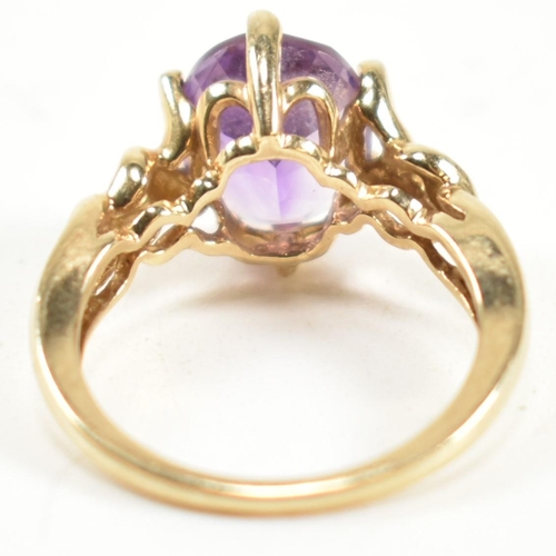 248 - A hallmarked 9ct gold and amethyst ring. The ring having a central six claw set oval cut amethyst to... 