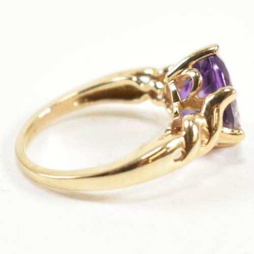 248 - A hallmarked 9ct gold and amethyst ring. The ring having a central six claw set oval cut amethyst to... 