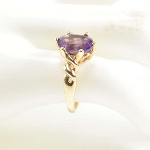 248 - A hallmarked 9ct gold and amethyst ring. The ring having a central six claw set oval cut amethyst to... 