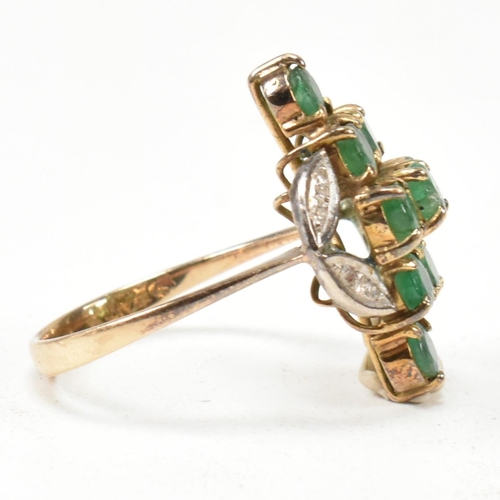 250 - An emerald and diamond cluster ring. The ring set with round cut emeralds in a diamond cluster havin... 