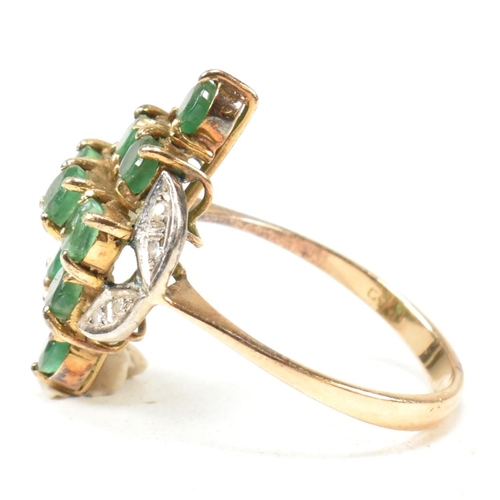 250 - An emerald and diamond cluster ring. The ring set with round cut emeralds in a diamond cluster havin... 