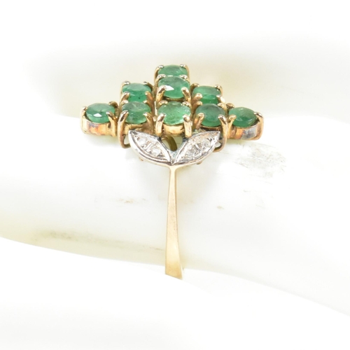 250 - An emerald and diamond cluster ring. The ring set with round cut emeralds in a diamond cluster havin... 