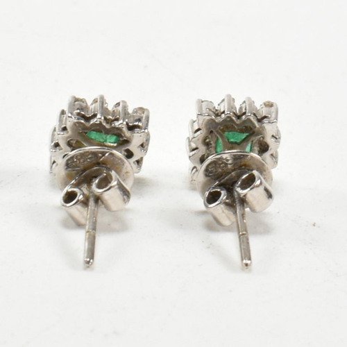 251 - A pair of white gold emerald and diamond cluster earrings. Butterfly fasteners marked 585. Weight 3.... 