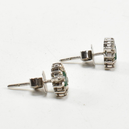 251 - A pair of white gold emerald and diamond cluster earrings. Butterfly fasteners marked 585. Weight 3.... 