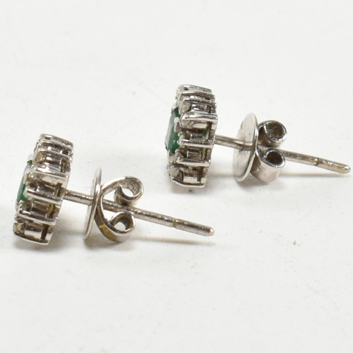 251 - A pair of white gold emerald and diamond cluster earrings. Butterfly fasteners marked 585. Weight 3.... 