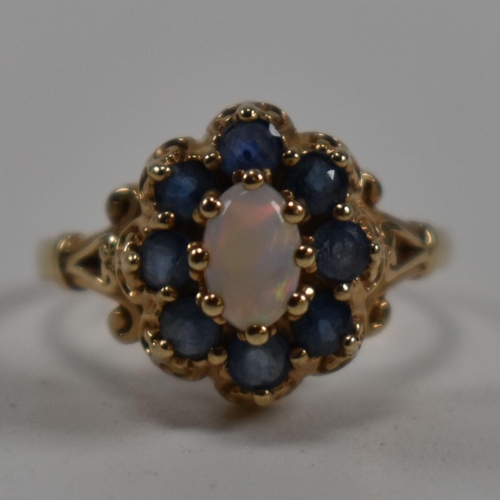 252 - A hallmarked 9ct gold, sapphire and opal cluster ring. The ring set with a central oval opal cabocho... 