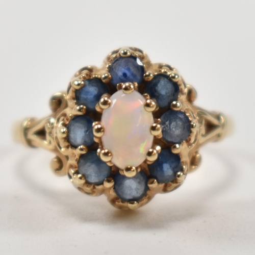 252 - A hallmarked 9ct gold, sapphire and opal cluster ring. The ring set with a central oval opal cabocho... 