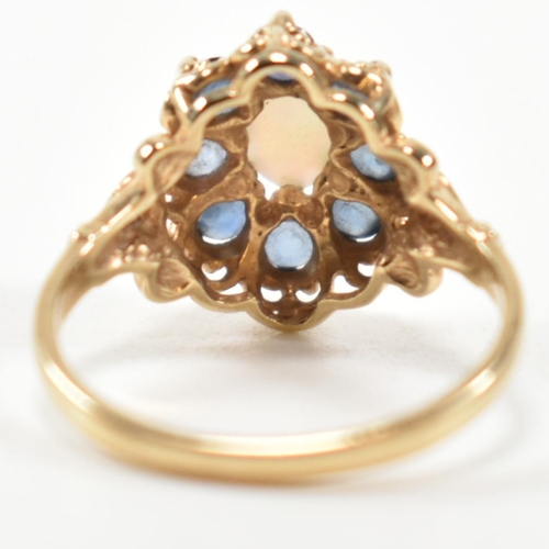 252 - A hallmarked 9ct gold, sapphire and opal cluster ring. The ring set with a central oval opal cabocho... 