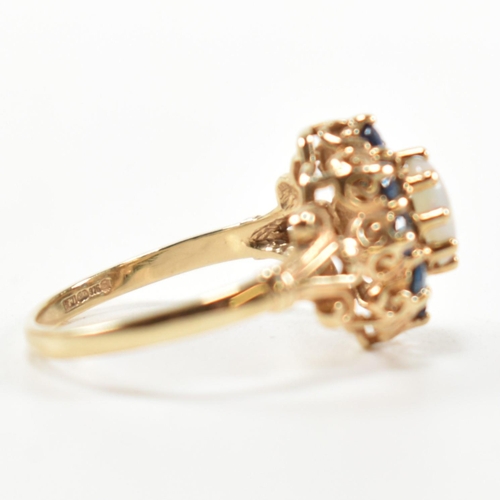 252 - A hallmarked 9ct gold, sapphire and opal cluster ring. The ring set with a central oval opal cabocho... 