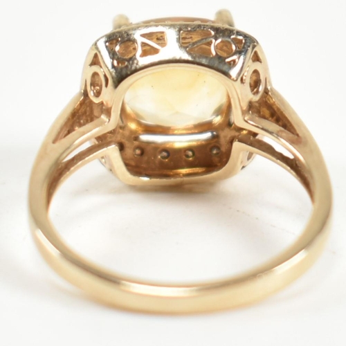 257 - A hallmarked 9ct gold, citrine and diamond ring. The ring set with a central cushion cut citrine sur... 