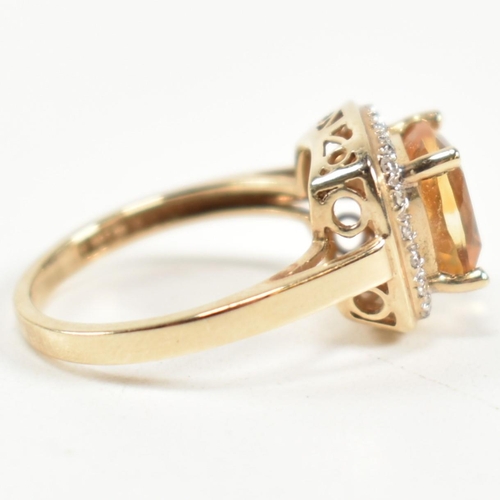 257 - A hallmarked 9ct gold, citrine and diamond ring. The ring set with a central cushion cut citrine sur... 