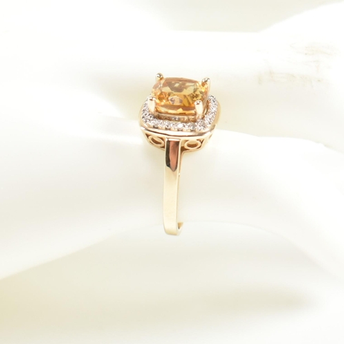 257 - A hallmarked 9ct gold, citrine and diamond ring. The ring set with a central cushion cut citrine sur... 