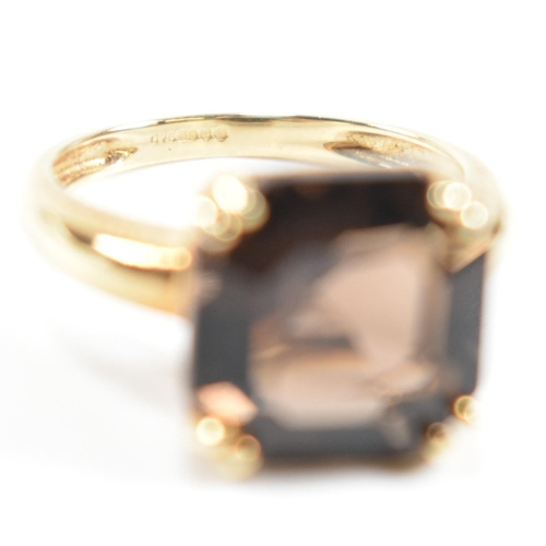 261 - A hallmarked 9ct gold and smoky quartz ring. The ring set with a single double claw set smoky quartz... 