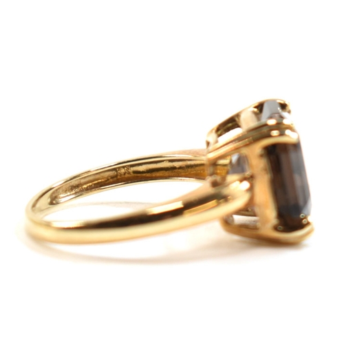 261 - A hallmarked 9ct gold and smoky quartz ring. The ring set with a single double claw set smoky quartz... 