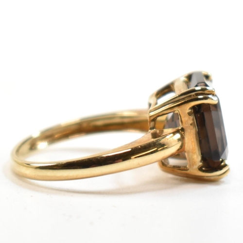 261 - A hallmarked 9ct gold and smoky quartz ring. The ring set with a single double claw set smoky quartz... 