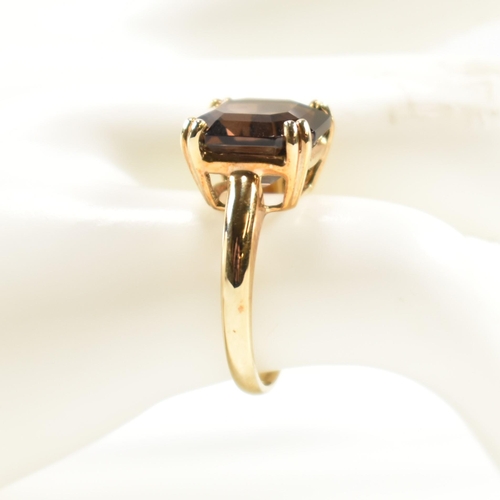 261 - A hallmarked 9ct gold and smoky quartz ring. The ring set with a single double claw set smoky quartz... 