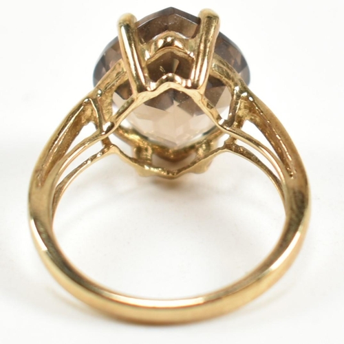 274 - A hallmarked 9ct gold and smoky quartz ring. The ring having a single four claw set wide marquise cu... 