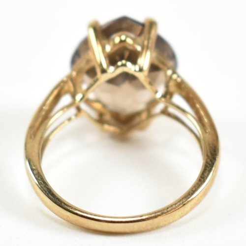 274 - A hallmarked 9ct gold and smoky quartz ring. The ring having a single four claw set wide marquise cu... 