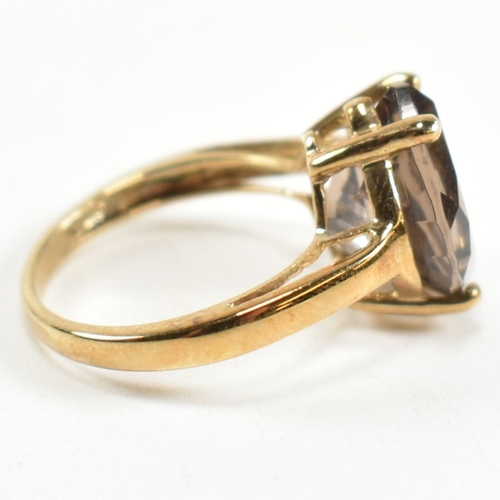 274 - A hallmarked 9ct gold and smoky quartz ring. The ring having a single four claw set wide marquise cu... 