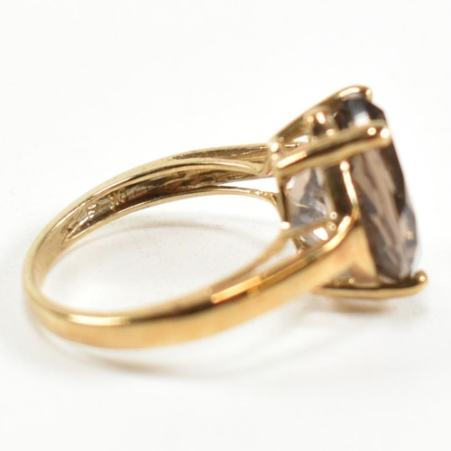 274 - A hallmarked 9ct gold and smoky quartz ring. The ring having a single four claw set wide marquise cu... 