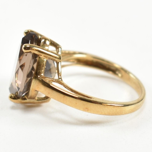 274 - A hallmarked 9ct gold and smoky quartz ring. The ring having a single four claw set wide marquise cu... 