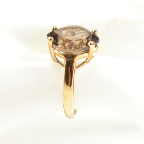 274 - A hallmarked 9ct gold and smoky quartz ring. The ring having a single four claw set wide marquise cu... 