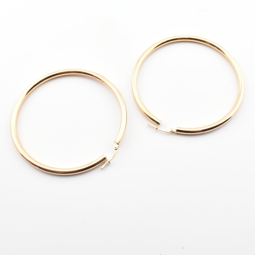 275 - A pair of hallmarked 9ct gold tube hoop earrings. The 9ct gold hoop earrings hallmarked for Arezzo, ... 