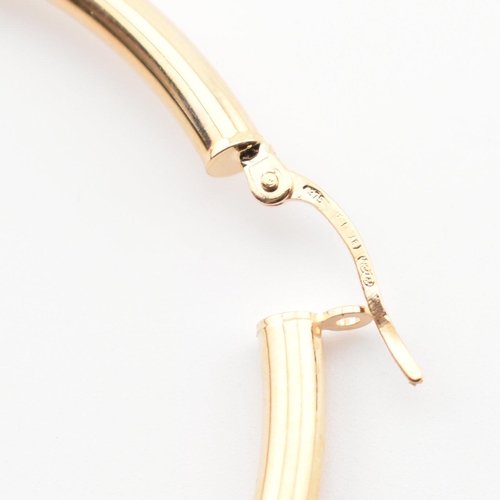 275 - A pair of hallmarked 9ct gold tube hoop earrings. The 9ct gold hoop earrings hallmarked for Arezzo, ... 