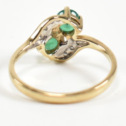 279 - A hallmarked 9ct gold, emerald and diamond crossover ring. The ring set with two four claw round cut... 