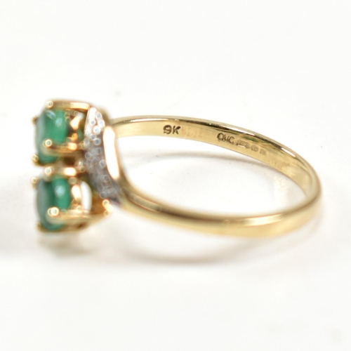 279 - A hallmarked 9ct gold, emerald and diamond crossover ring. The ring set with two four claw round cut... 