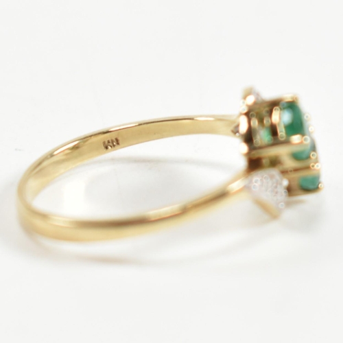 279 - A hallmarked 9ct gold, emerald and diamond crossover ring. The ring set with two four claw round cut... 