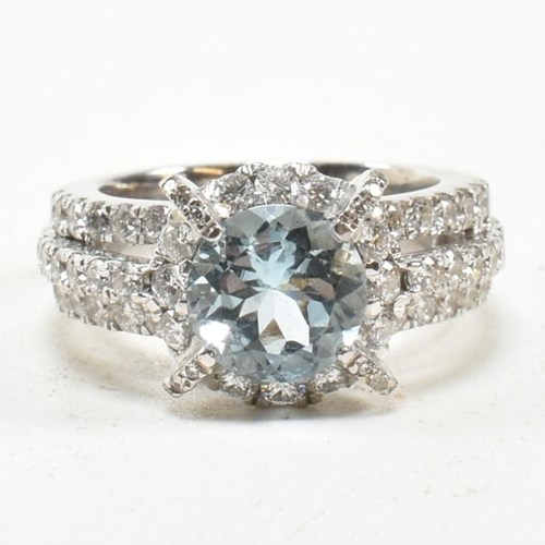 280 - An 18ct white gold, aquamarine and diamond cluster ring. The ring set with a central round mixed cut... 