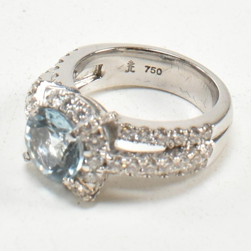 280 - An 18ct white gold, aquamarine and diamond cluster ring. The ring set with a central round mixed cut... 