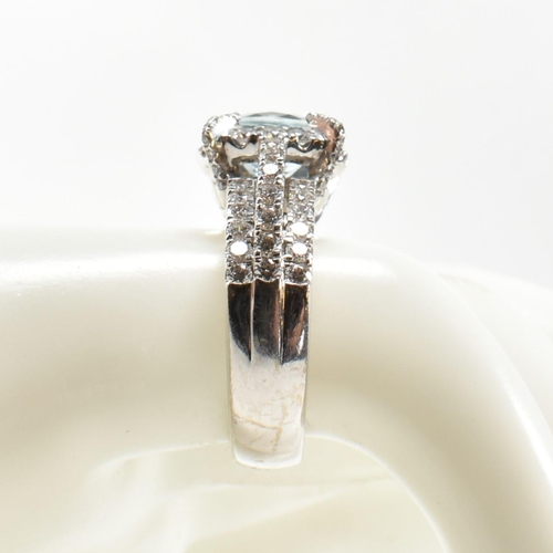 280 - An 18ct white gold, aquamarine and diamond cluster ring. The ring set with a central round mixed cut... 