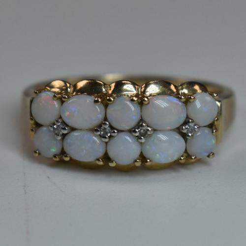 282 - A hallmarked 9ct gold, diamond and opal ring. The ring having two rows of mixed oval and round opal ... 