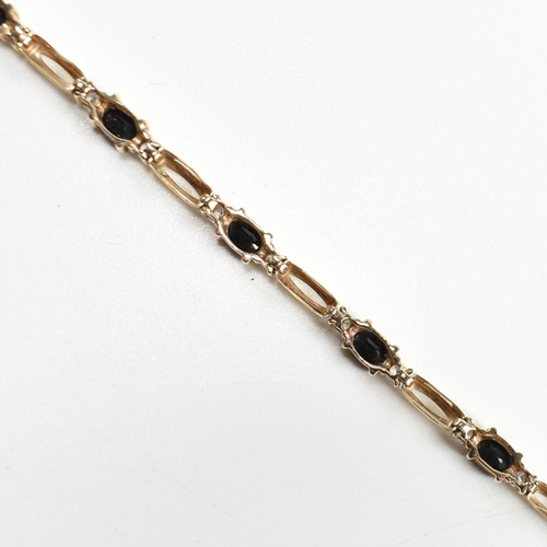 286 - A 9ct gold, sapphire and CZ line bracelet. The bracelet having links set with nine east-west set ova... 