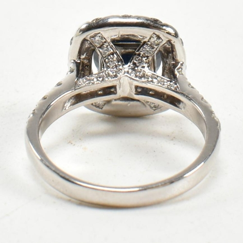 291 - A 14ct white gold, sapphire and diamond halo ring. The ring set with a central round mixed cut sapph... 