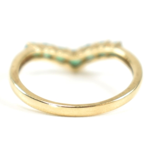 292 - A hallmarked 9ct gold and emerald wishbone ring. The ring set with a single row of shared claw round... 