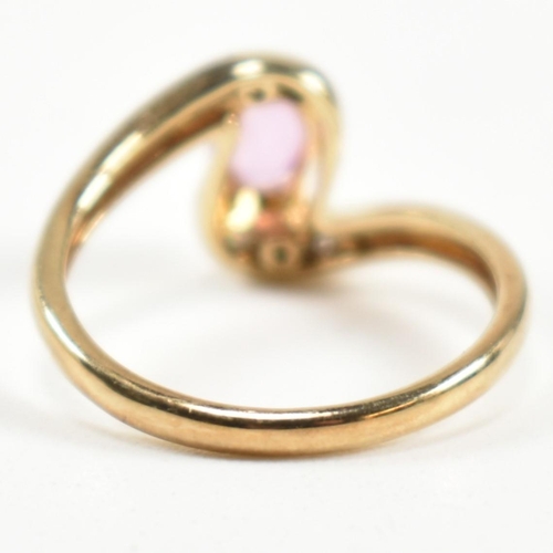 296 - A hallmarked 9ct gold, pink sapphire and diamond crossover ring. The ring set with a central four cl... 