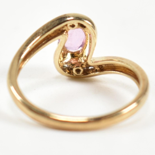 296 - A hallmarked 9ct gold, pink sapphire and diamond crossover ring. The ring set with a central four cl... 