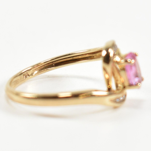 296 - A hallmarked 9ct gold, pink sapphire and diamond crossover ring. The ring set with a central four cl... 