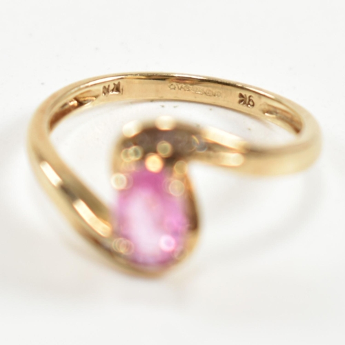 296 - A hallmarked 9ct gold, pink sapphire and diamond crossover ring. The ring set with a central four cl... 