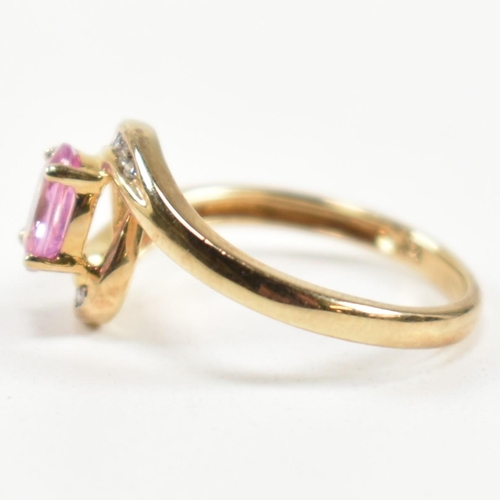 296 - A hallmarked 9ct gold, pink sapphire and diamond crossover ring. The ring set with a central four cl... 