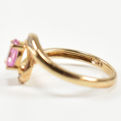 296 - A hallmarked 9ct gold, pink sapphire and diamond crossover ring. The ring set with a central four cl... 