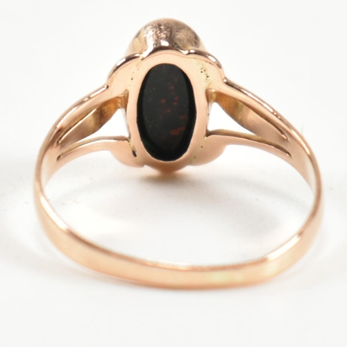 299 - A gold and bloodstone ring. The ring set with a bezel set oval cut bloodstone to pierced shoulders. ... 