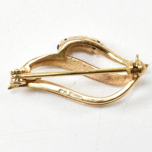 301 - A hallmarked 9ct gold sapphire brooch pin. The brooch in the form of a leaf set with round cut sapph... 