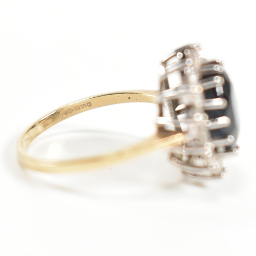 318 - A hallmarked 9ct gold, sapphire and CZ ring. The ring having a central oval cut sapphire surrounded ... 